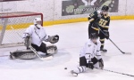 Goaltender Graham Hildebrand makes a save, as the shot sneaks by Dillon Forbes.